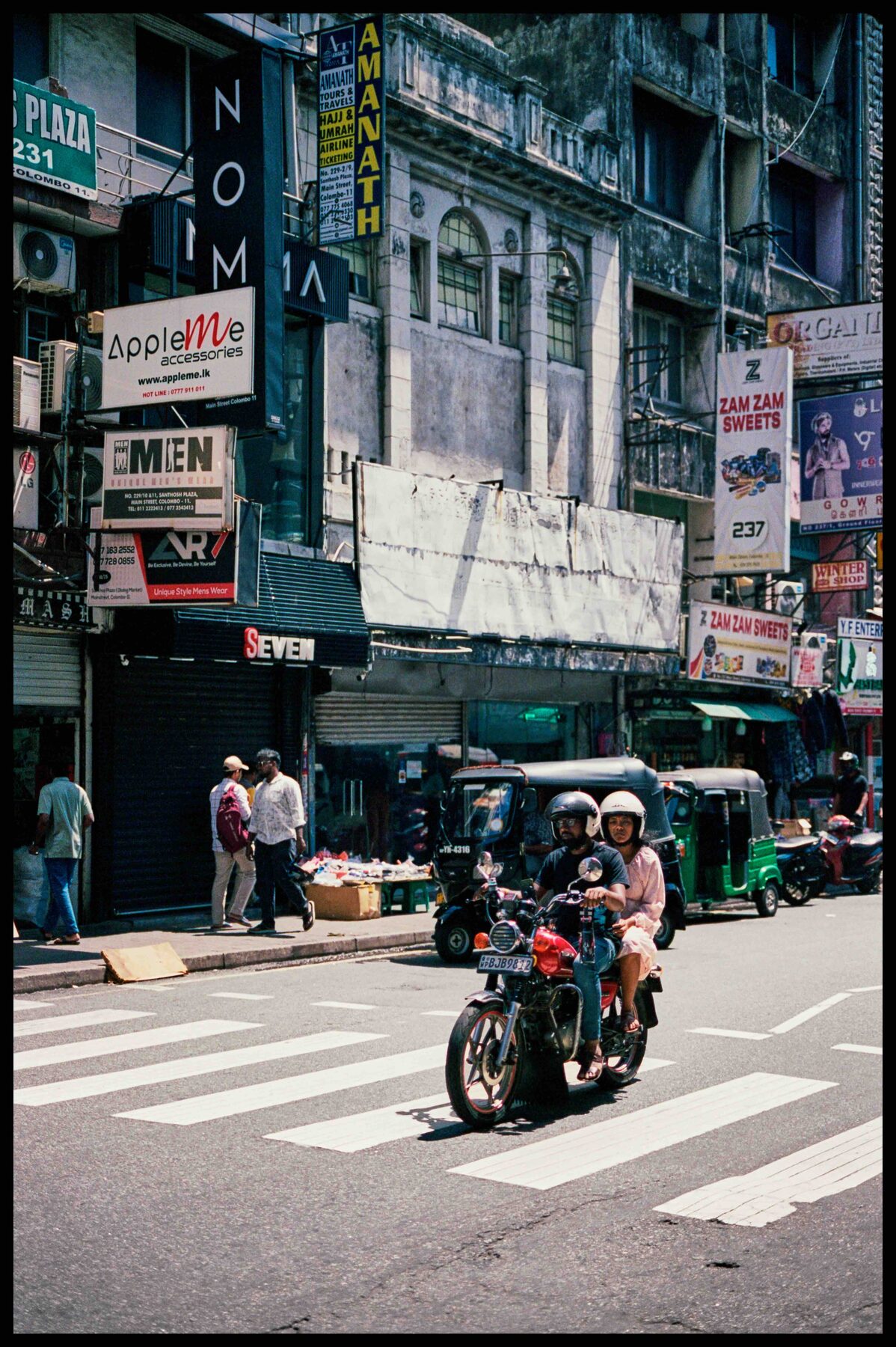 Colombo – Motorrad auf einer Straße mit Tuk-Tuks
