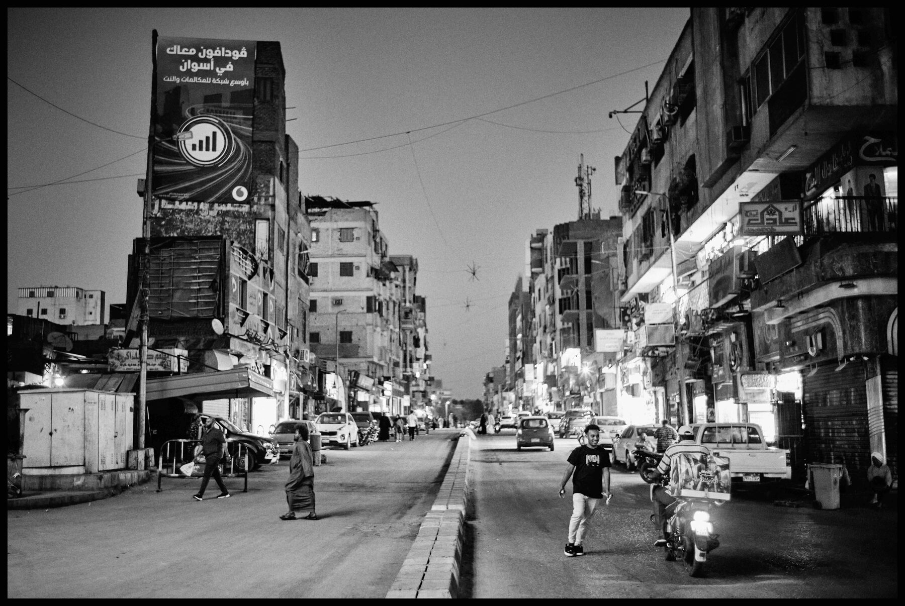 Aswan – abendliche Straße mit Passanten und Motorrad