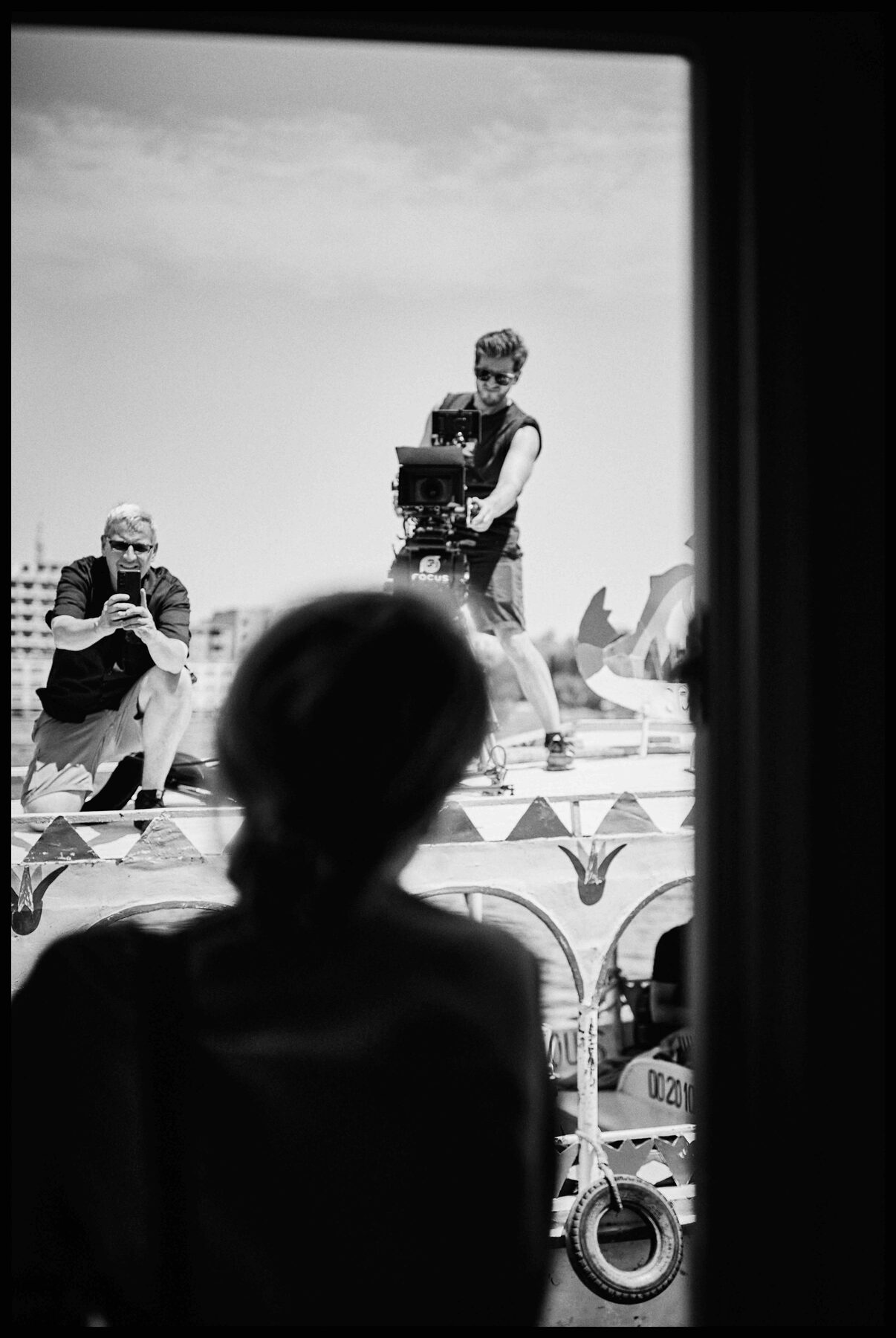 Luxor – Blick durch ein Fenster auf zwei Fotografen an Deck
