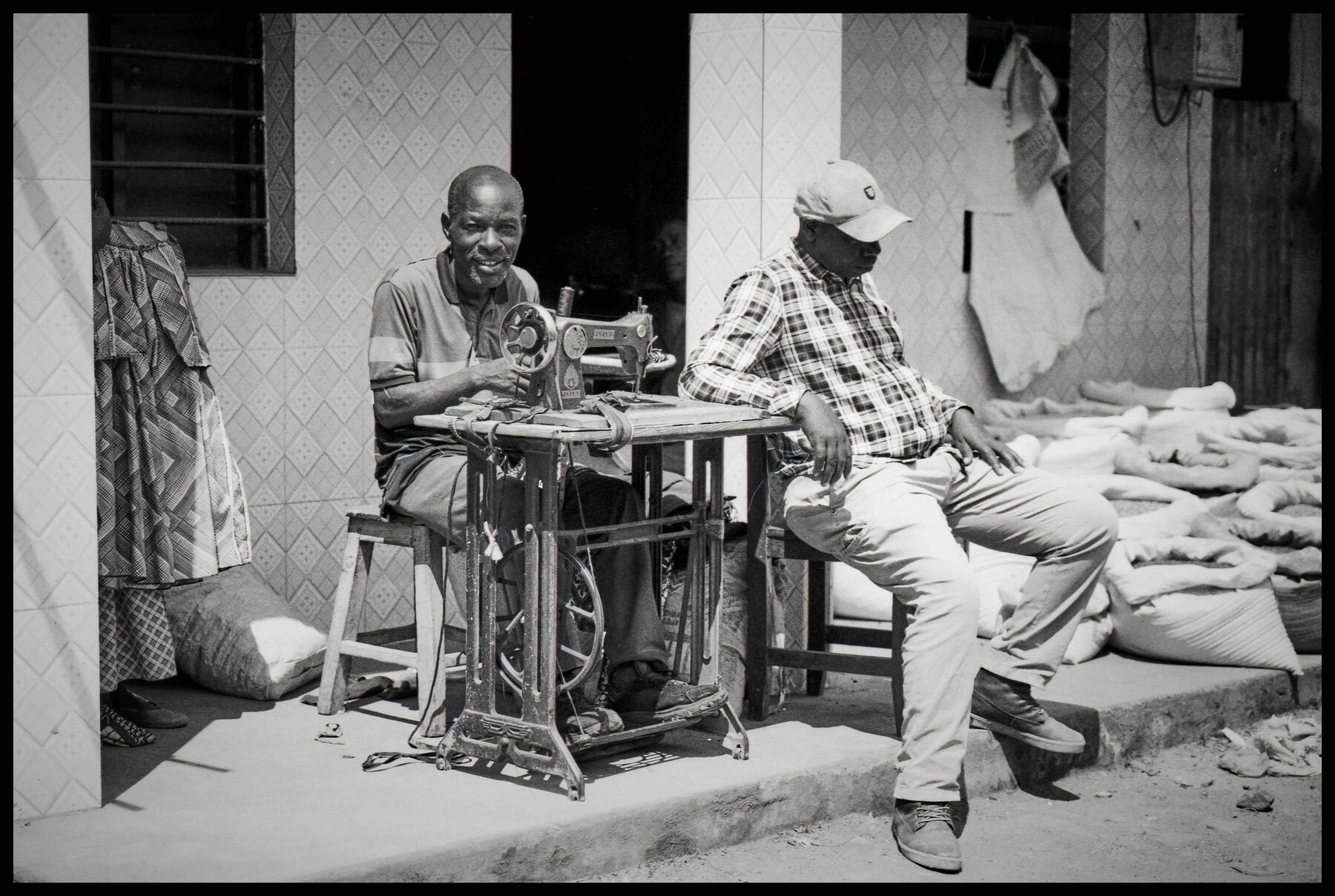 Ruanda – Schneider an der Nähmaschine vor einem Haus