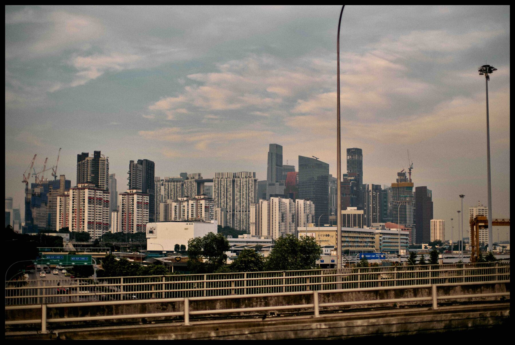 Singapur – Skyline von Singapur im Abendlicht hinter einer Brücke